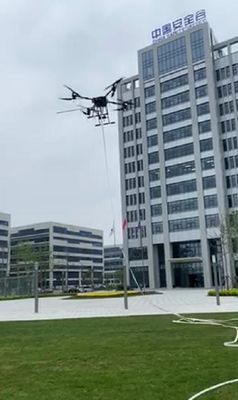 Funktions-bespritzen feuerbekämpfender Brummen Uav der zerbrochenen Fensterscheibe das Festmachen der Art mit einem Schlauch